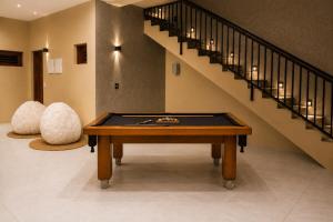 a room with a pool table and a staircase at Dona Chica Wellness Center in Taíba