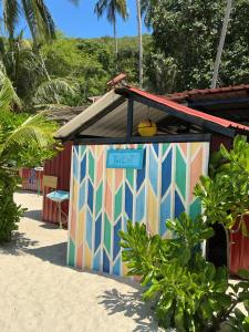 a colorful building with a sign on it on the beach at Redang Campstay in Redang Island +20 photos