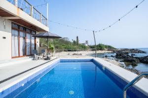 a swimming pool with a view of the ocean at Sofia - Summer Coastal Suites in Bacnotan