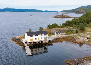 a house on an island in a body of water at Skjevlingsnes sjøhus in Tingvoll