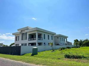 a large white house on a hill with a yard at Bountiful Estates Fantasy in Nadi
