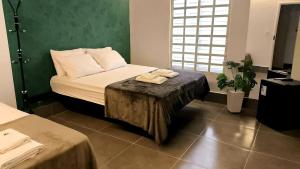 a bedroom with a bed and a table with towels on it at Gyn Suítes - Suítes novas e funcionais in Goiânia +82 photos