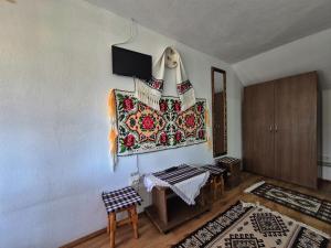 a room with a table and a rug on a wall at Casa Grigor in Călineşti