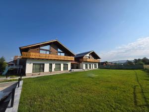 a house with a large lawn in front of it at Austrian Villa's in Covasna
