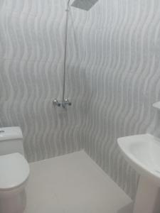 a white bathroom with a toilet and a sink at مغيضة للشقق المخدومة in Hail