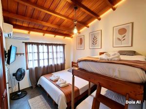 two beds in a room with wooden ceilings at CONFORT Room AIRE AC - Desayuno - Tv - Baño Compartido - Excelente Ubicación Muelle Cruceros - Exquisita Atención y Buen Ambiente in Cartagena de Indias