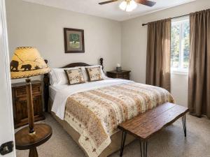 a bedroom with a bed and a lamp and a window at Chalet Rouge in Ruidoso