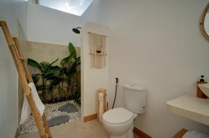 a bathroom with a white toilet in a room at Bellis Garden in Kuta Lombok