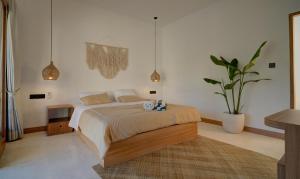 a bedroom with a bed and a potted plant at Bellis Garden in Kuta Lombok