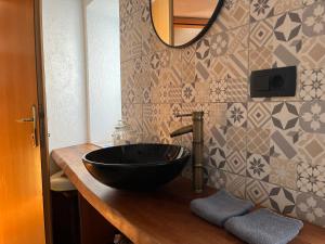 a bathroom with a black bowl sink on a counter at Apartment Lagma in Železniki +4 photos