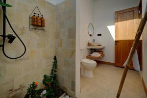 a bathroom with a shower and a toilet in it at Bellis Garden in Kuta Lombok