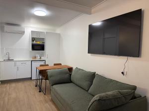a living room with a couch and a table and a kitchen at Pearly Shell Motel in Bowen