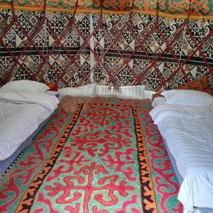 a room with two beds and a patterned wall at Kapchygai Yurt Camp in Dzhetyoguz