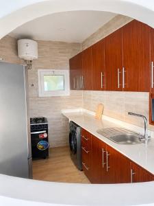 a kitchen with wooden cabinets and a sink and a stove at TchaoPremium in Lomé