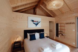 a bedroom with a bed in a wooden cabin at Le Clos des Pies in Le Pin