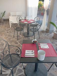 a patio with two tables and chairs with red napkins at BF SUITE Foresteria Bellusci in Rho