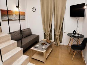 a living room with a couch and a table at SmallHouseLefkada ΘΕΜΑ in Lefkada