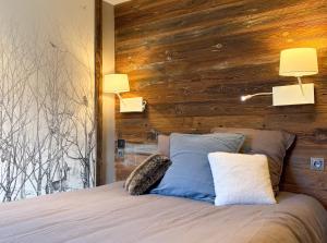 a bedroom with a bed with two pillows and two lamps at Homency - Résidence Ménandière V2 spot in L'Alpe-d'Huez