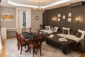 a room with two beds and a table with chairs at Mozart & Bach Historic Apartment in Sibiu