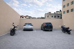 three cars and motorcycles parked in a parking lot at Hotel Apple Park - A Boutique Hotel with Free Airport Tranfer in New Delhi
