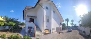 a white house with a stairway to the backdoor at Le camere di Gaudré in Battipaglia