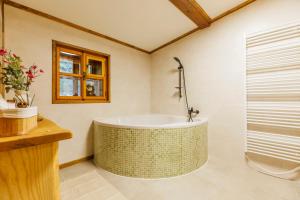 a bath tub in a bathroom with a window at Chalupa Vysoký Potok in Malá Morava +46 photos