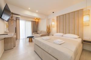 a hotel room with a large bed and a television at MaDaM Essence in Nei Poroi