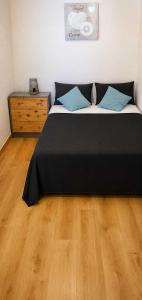 a bedroom with a black bed with a wooden floor at Casa Lago in Zaragoza