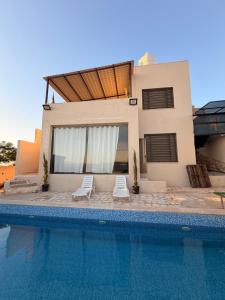 a house with a swimming pool in front of a house at Luxury Mountain Chalet with Private Pool Lionden Jerash in Jerash