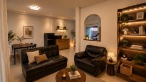 a living room with black leather furniture and a table at City Hill Residence in Ban Khok Chang