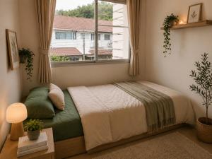 a bedroom with a bed and a window at City Hill Residence in Ban Khok Chang