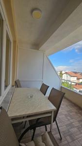 a room with a table and chairs on a balcony at Apartments LOTUS in Gevgelija