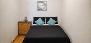 a bedroom with a black bed with blue pillows at Casa Lago in Zaragoza