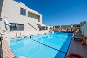 a swimming pool in front of a building at Evina Rooms & Suites in Kokkini Khanion