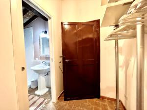 a bathroom with a toilet and a brown door at Villa Pasqui 1914 e Limonaia in Città di Castello