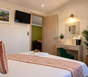 a hotel room with a bed with a television on the wall at Sea breeze 2 in Limenaria