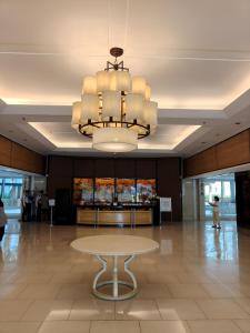 a table in the middle of a lobby with a chandelier at MOA shell residences - JOSH in Manila +27 photos