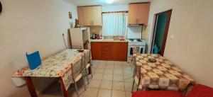 a small kitchen with two tables and a refrigerator at Argiro studios in Flogita