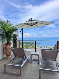 a patio with two chairs and an umbrella at LOLISEA Luxe view villas in Salad Beach