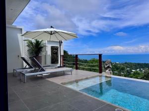 a villa with a swimming pool and an umbrella at LOLISEA Luxe view villas in Salad Beach