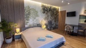 a bedroom with a bed with two towels on it at Sétány Apartman-és Vendégház in Tiszafüred