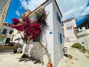 a building with flowers on the side of it at Island Traditional House in Poros
