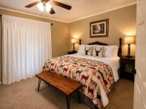 a bedroom with a bed and a ceiling fan at Chalet Rouge in Ruidoso