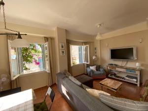 a living room with a couch and a tv at Island Traditional House in Poros