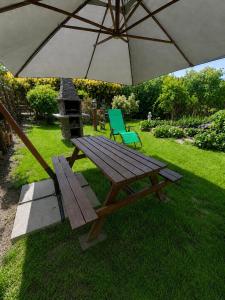 a picnic table and a chair under an umbrella at Agroturystyka Hogata in Wąchock +8 photos