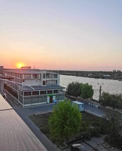 a building next to a river with the sunset at Delta Palace in Sulina