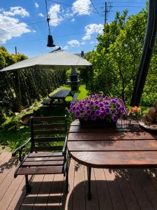 a wooden table with a bench and a bowl of purple flowers at Agroturystyka Hogata in Wąchock