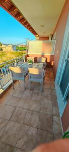 a patio with a table and chairs on a balcony at Argiro studios in Flogita