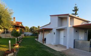 a white house with a gate and a yard at SmallHouseLefkada ΘΕΜΑ in Lefkada