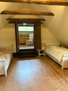 a attic room with two beds and a mirror at Urikivi Holiday House in Orjaku